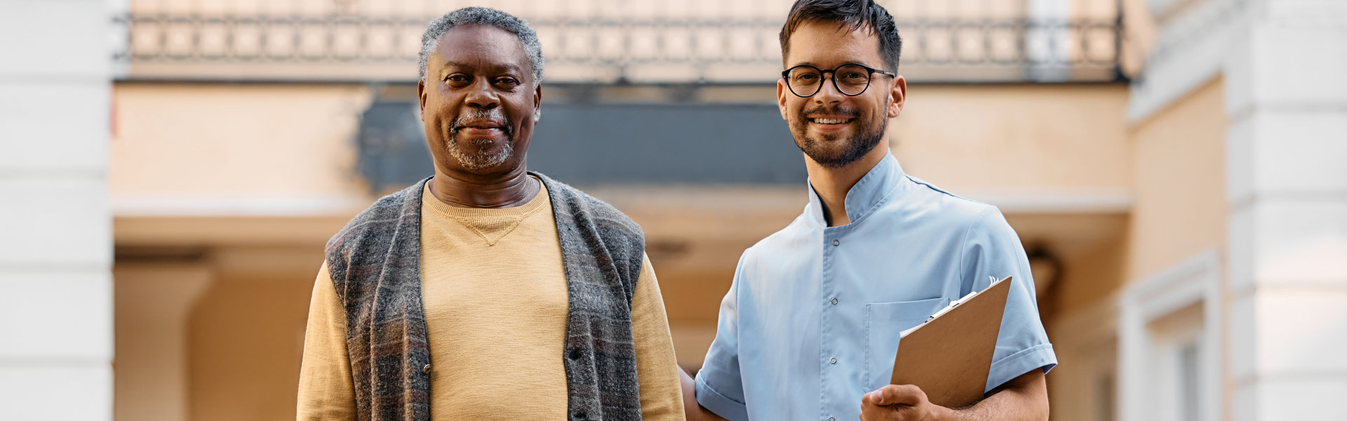 An elderly man and a male smiling together