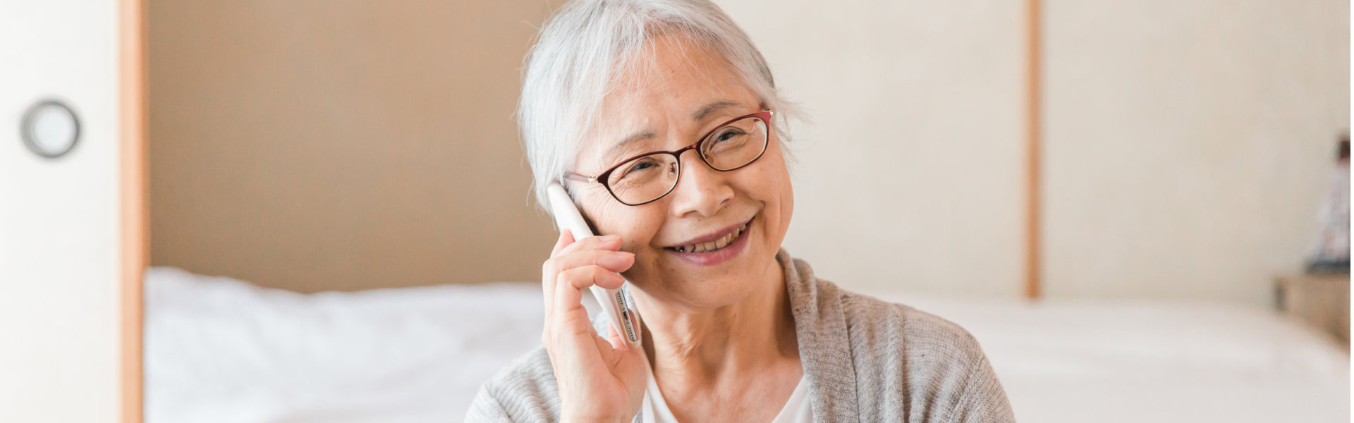 An elderly woman calling through a mobile phone